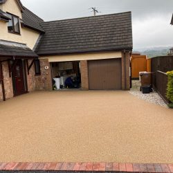 Choosing the right Paving Material for your driveway with a Resin Driveway to match the brick on a modern house